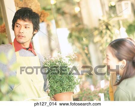 Male florist talking to female customer View Large Photo Image Picture - Male florist talking to female customer. Fotosearch