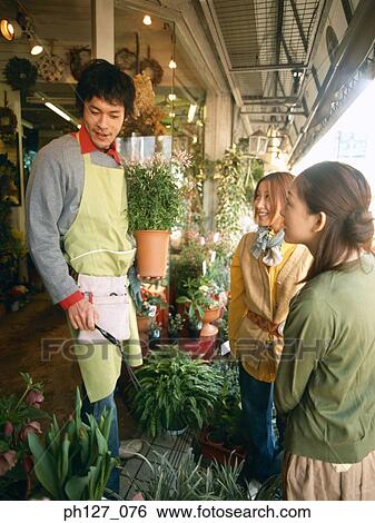 Male florist talking to female customers View Large Photo Image Stock Photograph - Male florist talking to female customers. Fotosearch