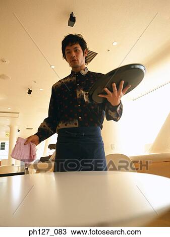Male waiter holding a serving tray and cloth View Large Photo Image Stock Image - Male waiter holding a serving tray and cloth. Fotosearch