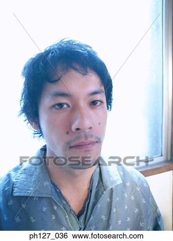 Portrait of a young Asian man View Large Photo Image Stock Photograph - Portrait of a young Asian man. Fotosearch
