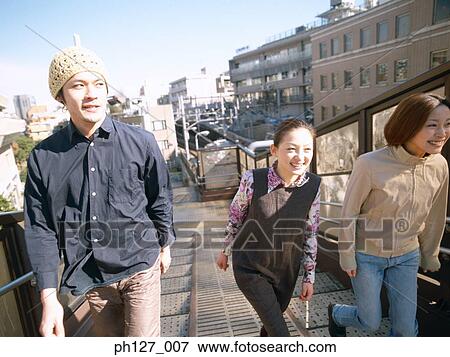 Three friends walking on the street View Large Photo Image Stock Photo - Three friends walking on the street. Fotosearch