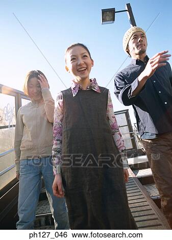 Three friends walking on the street View Large Photo Image Stock Photograph - Three friends walking on the street. Fotosearch