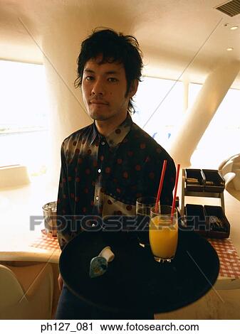 Waiter carrying cold beverages on a tray View Large Photo Image Stock Image - Waiter carrying cold beverages on a tray. Fotosearch