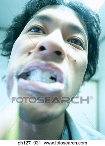 Young man brushing his teeth, close-up View Large Photo Image Stock Image - Young man brushing his teeth, close-up. Fotosearch