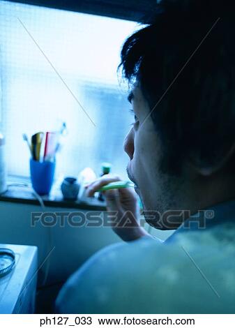 Young man brushing his teeth, close-up View Large Photo Image Stock Image - Young man brushing his teeth, close-up. Fotosearch