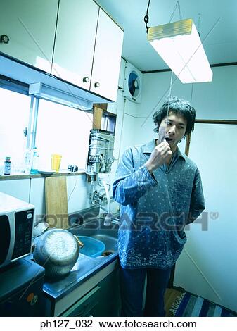 Stock Image - Young man brushing his teeth. Fotosearch