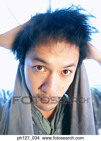 Young man drying his hair with towel, close-up View Large Photo Image Picture - Young man drying his hair with towel, close-up. Fotosearch