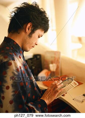 Stock Photo - Young man using digital device. Fotosearch
