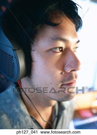 Young man wearing headphones, close-up View Large Photo Image Stock Image - Young man wearing headphones, close-up. Fotosearch