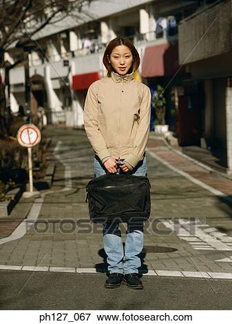 Young woman holding a briefcase View Large Photo Image Stock Photo - Young woman holding a briefcase. Fotosearch