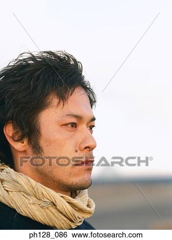 Stock Photograph - Portrait of a young Asian man, close-up. Fotosearch