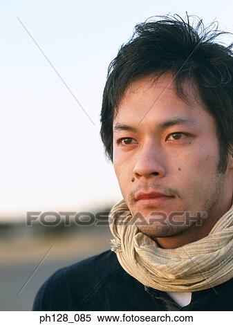Portrait of a young Asian man, close-up View Large Photo Image Stock Photography - Portrait of a young Asian man, close-up. Fotosearch