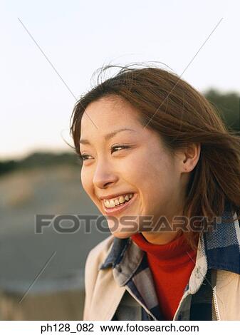 Portrait of a young Asian woman, smiling View Large Photo Image Stock Image - Portrait of a young Asian woman, smiling. Fotosearch