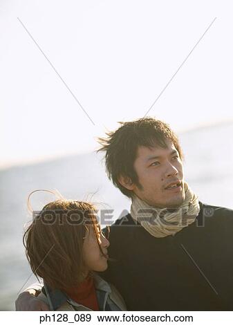 Stock Photo - Portrait of a young couple at the beach. Fotosearch