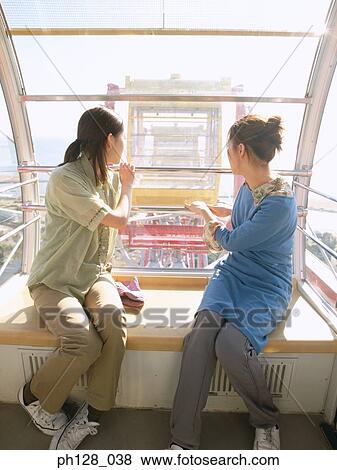 Portrait of two young women in Ferris wheel, looking back View Large Photo Image Stock Photo - Portrait of two young women in Ferris wheel, looking back. Fotosearch