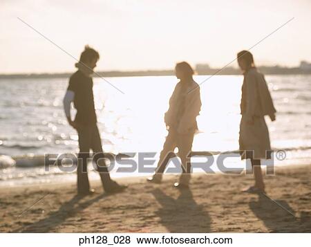 Three people at the beach, silhouette View Large Photo Image Stock Photo - Three people at the beach, silhouette. Fotosearch