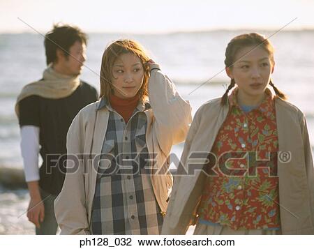 Stock Image - Three people at the beach. Fotosearch