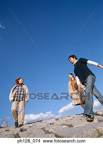 Three people walking on water-breaker View Large Photo Image Picture - Three people walking on water-breaker. Fotosearch