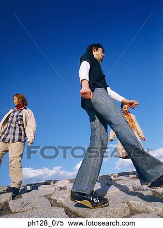Three people walking on water-breaker View Large Photo Image Stock Photography - Three people walking on water-breaker. Fotosearch