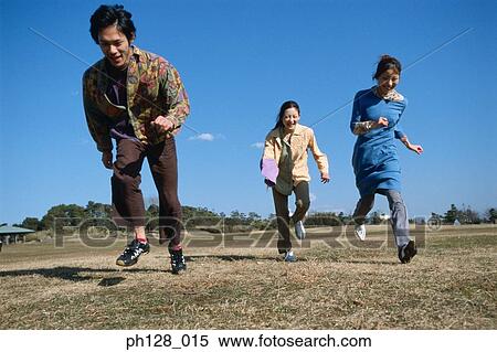 Stock Photography - Three young people hopping and laughing. Fotosearch