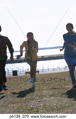 Three young people running and laughing View Large Photo Image Stock Image - Three young people running and laughing. Fotosearch