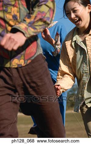 Three young people running and laughing View Large Photo Image Stock Photo - Three young people running and laughing. Fotosearch