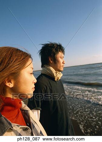 Young couple at the beach, side profile View Large Photo Image Stock Photo - Young couple at the beach, side profile. Fotosearch
