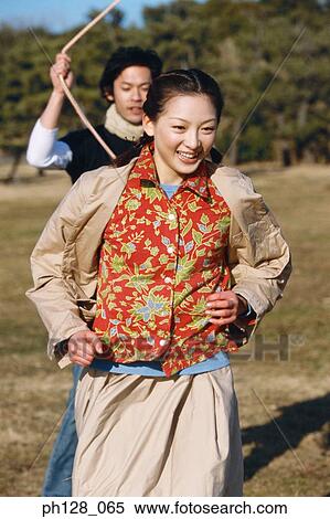 Young couple playing at a field View Large Photo Image Stock Photography - Young couple playing at a field. Fotosearch