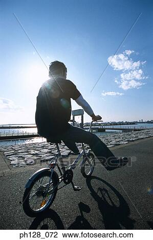 Young man riding on bicycle, silhouette View Large Photo Image Stock Image - Young man riding on bicycle, silhouette. Fotosearch