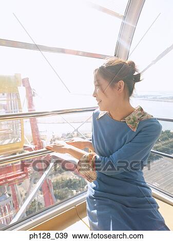Young woman in Ferris wheel, looking back View Large Photo Image Stock Photo - Young woman in Ferris wheel, looking back. Fotosearch