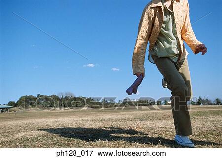 Stock Photo - Young woman running at a field. Fotosearch