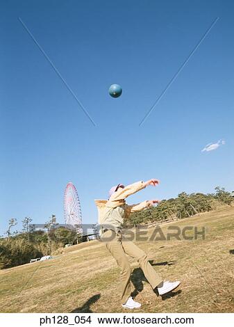 Picture - Young woman throwing a ball . Fotosearch