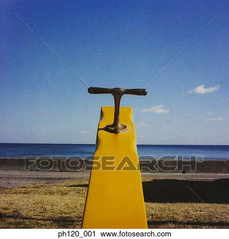 Stock Image - Seesaw by the beach. Fotosearch
