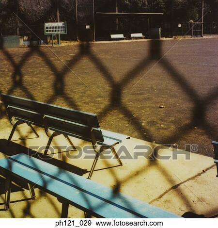 Stock Photo - Bench in a park, view outside fence. Fotosearch