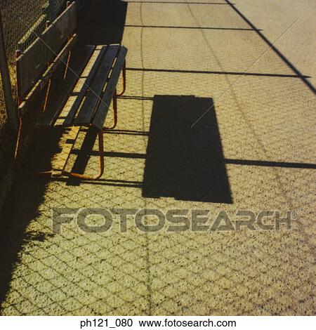 Stock Image - Empty bench on pavement. Fotosearch