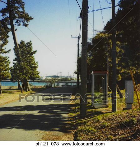 Stock Photo - Public phone booth by the pavement in a park. Fotosearch