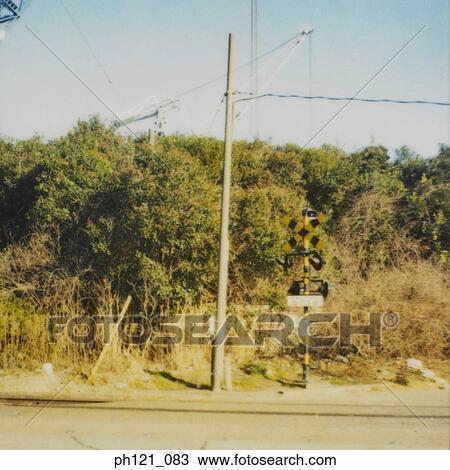 Stock Image - Railroad crossing by the roadside. Fotosearch
