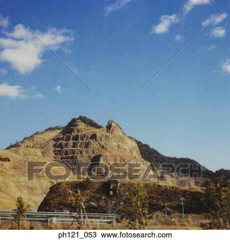 Stock Image - Rocky hill by the highway. Fotosearch
