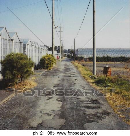 Stock Photography - Small uneven path behind a row of houses. Fotosearch