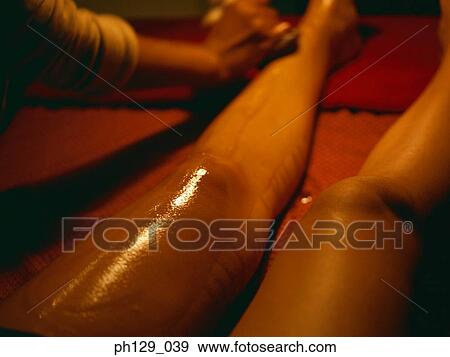 Stock Photo - Masseuse applying essential oil therapy. Fotosearch