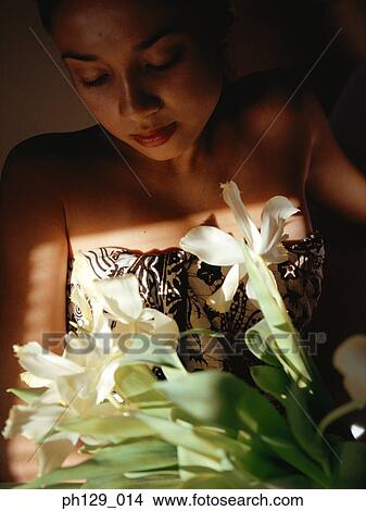 Picture - Woman holding a bouquet lily flowers, eyes closed. Fotosearch
