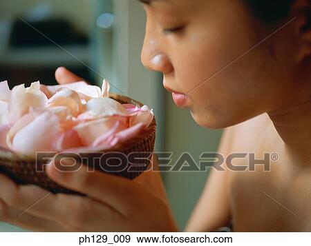 Stock Photo - Woman holding bowl of rose petals. Fotosearch