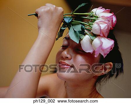 Woman holding stalks of roses, smiling View Large Photo Image Stock Image - Woman holding stalks of roses, smiling. Fotosearch