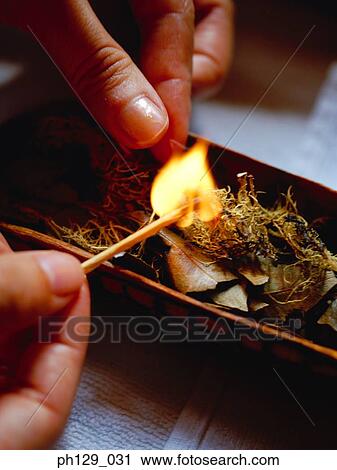 Woman lighting fire on herbs View Large Photo Image Stock Image - Woman lighting fire on herbs. Fotosearch