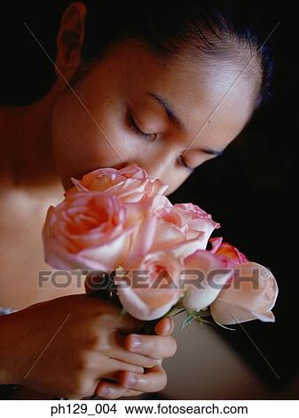 Picture - Young woman smelling rose, close-up . Fotosearch