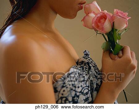 Stock Photograph - Young woman smelling rose, close-up . Fotosearch