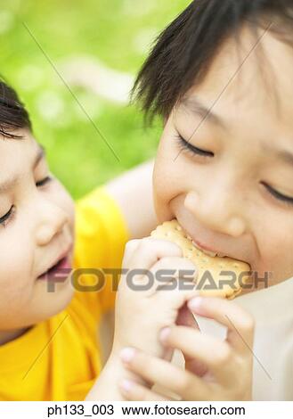 Stock Image - Children feeding each other. Fotosearch