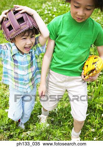 Two young boys smiling & walking with baseball mitts View Large Photo Image Stock Photography - Two young boys smiling & walking with baseball mitts. Fotosearch