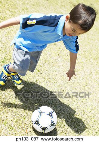 Young boy playing football View Large Photo Image Stock Photo - Young boy playing football. Fotosearch