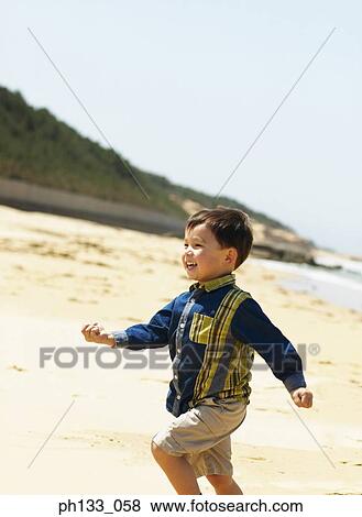 Young boy playing on beach View Large Photo Image Stock Photo - Young boy playing on beach. Fotosearch